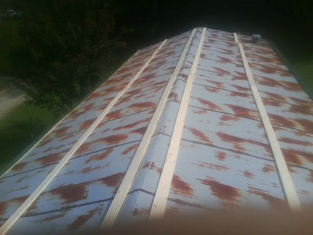 Rusted metal roof panels with new wood purlins before replacement — Storm Damage Roof Repair in Windham by Roofing Brothers